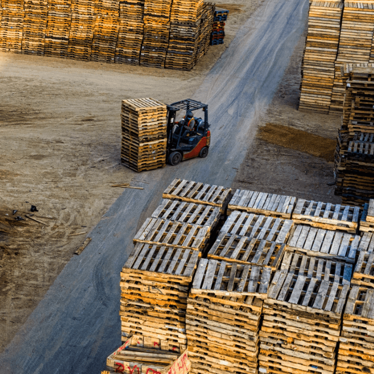 Equipa a trabalhar com monta cargas na Omega Pallets - empresa de paletes de madeira